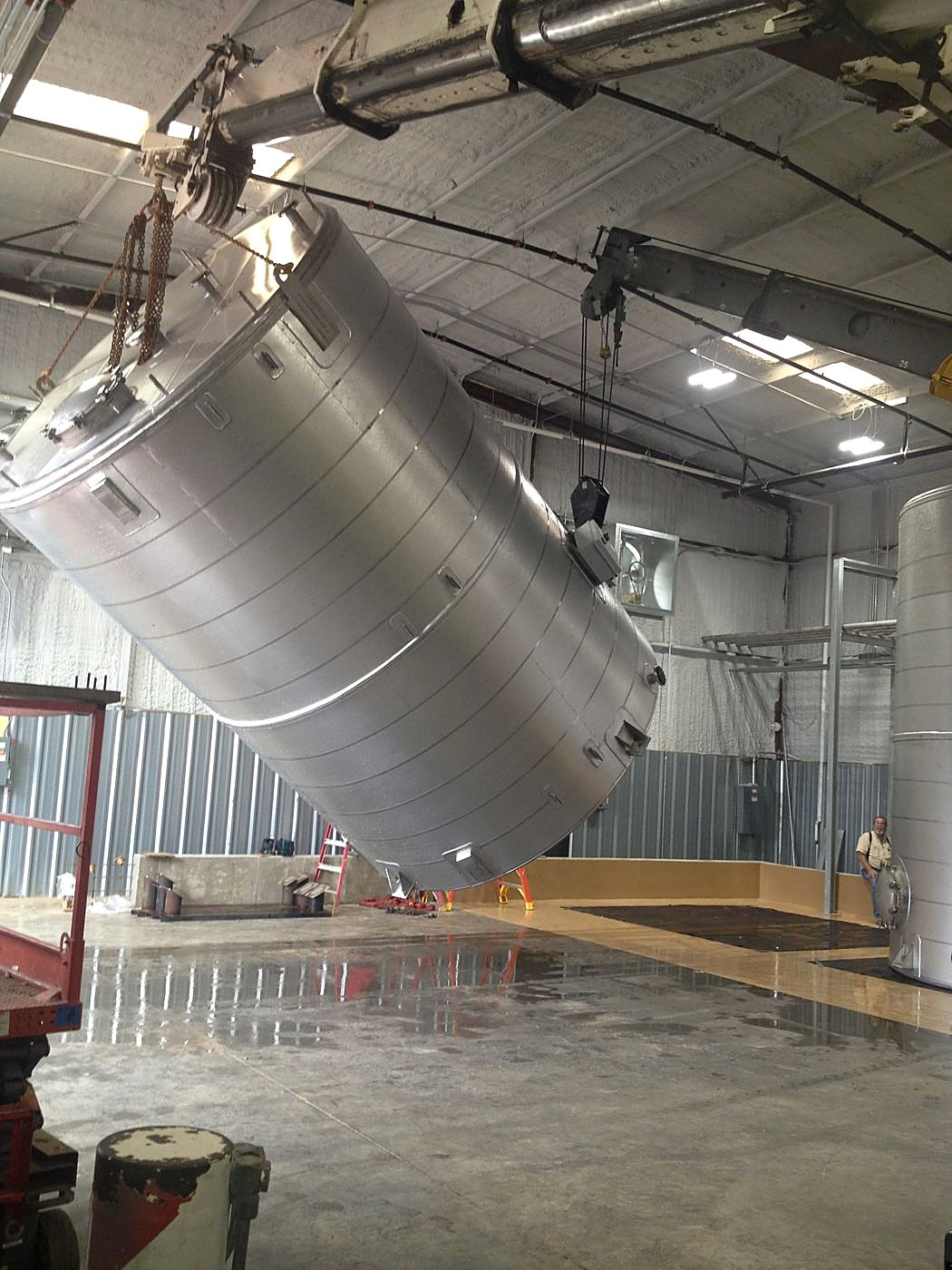 Rigging a stainless bulk tank into place at Creative Polymer Solutions