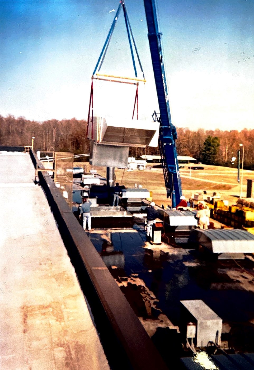 Crane setting a rooftop unit during a 1980s Hyster expansion